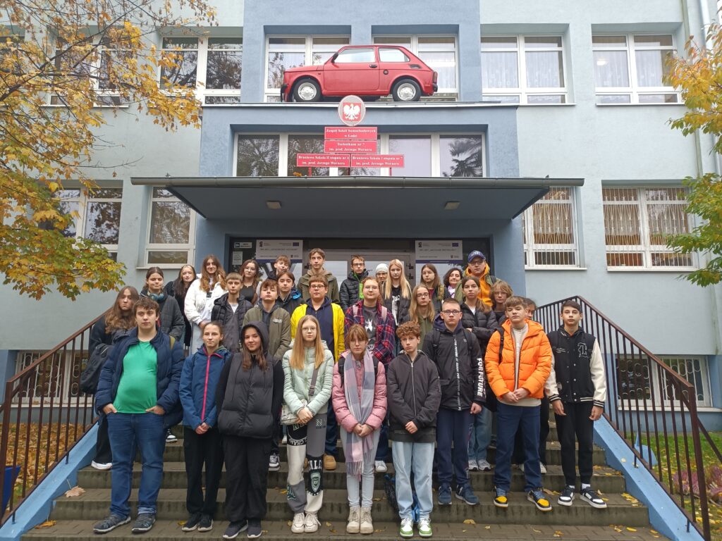 zdjęcie grupowe przed Zespołem Szkół Samochodowych