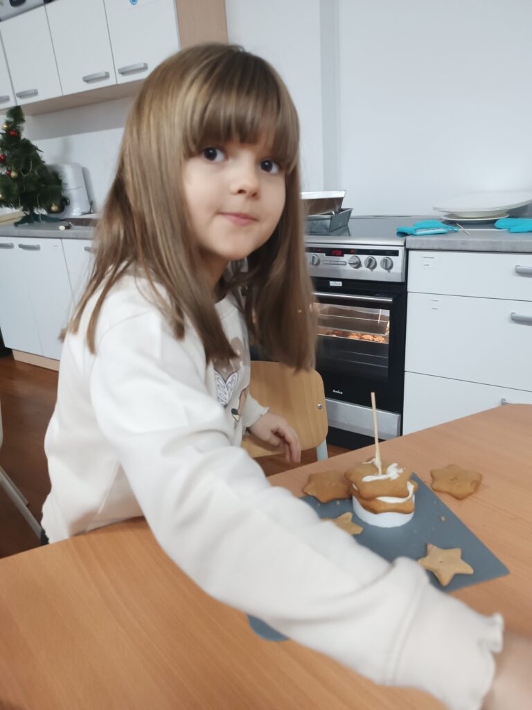 dziewczynka buduje choinkę z pierników