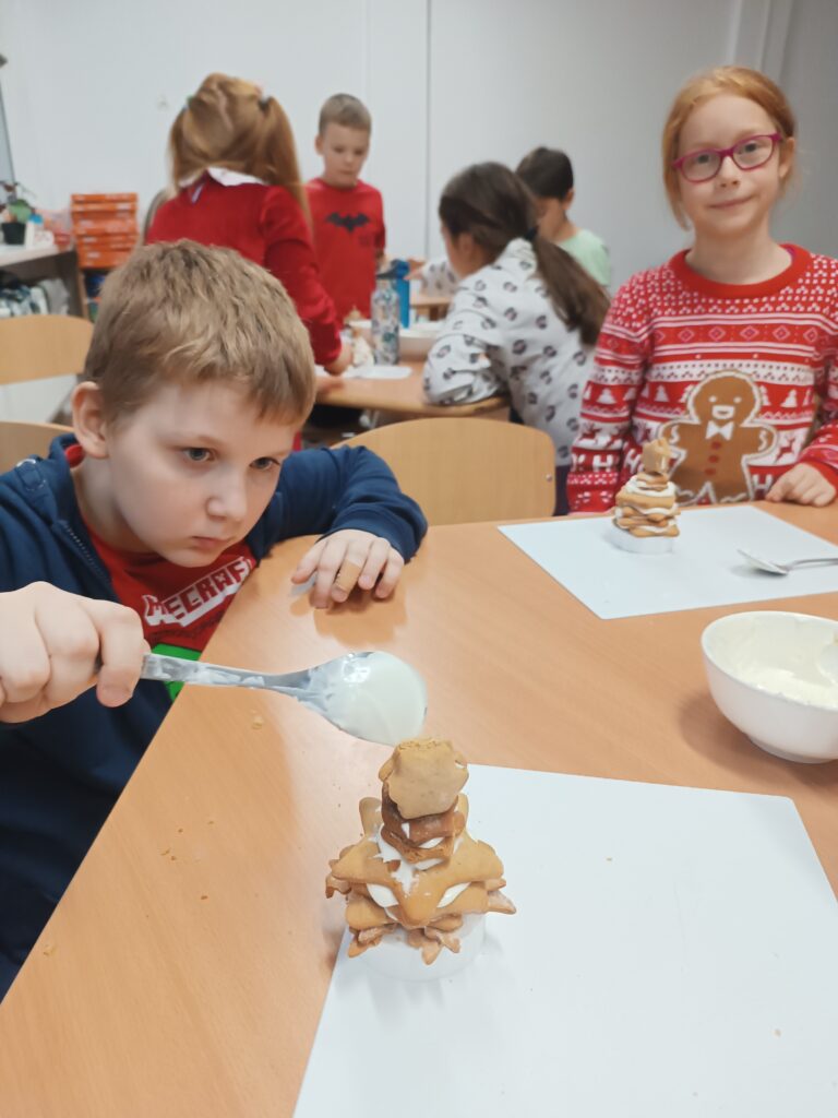 chłopiec skleja lukrem choinkę z pierników