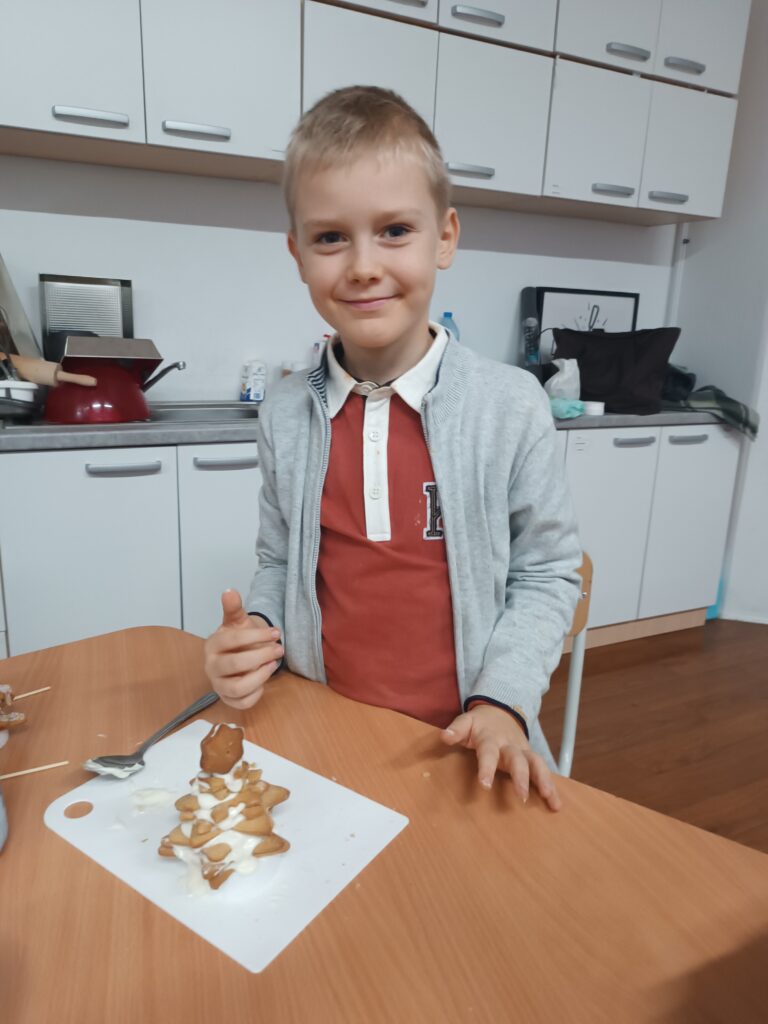 chłopiec prezentuje swoją choinkę z piernika