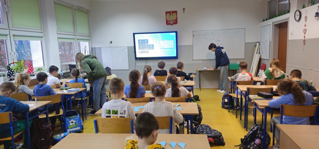 Na zdjęciu grupa dzieci składająca gwiazdy origami
