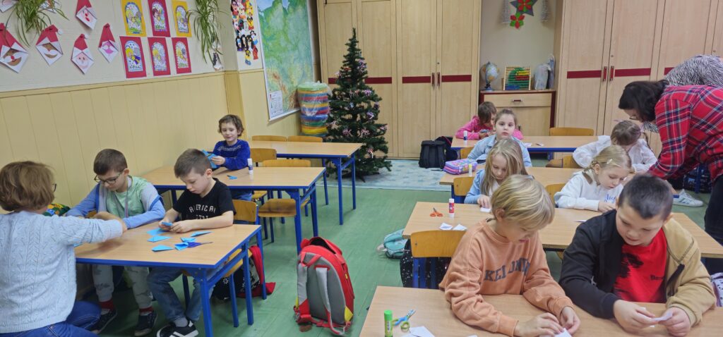 Na zdjęciu grupa dzieci składająca gwiazdy.