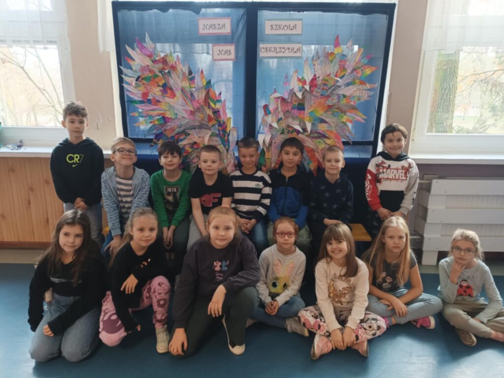 zdjęcie grupowe dzieci na tle ścianki ze skrzydłami