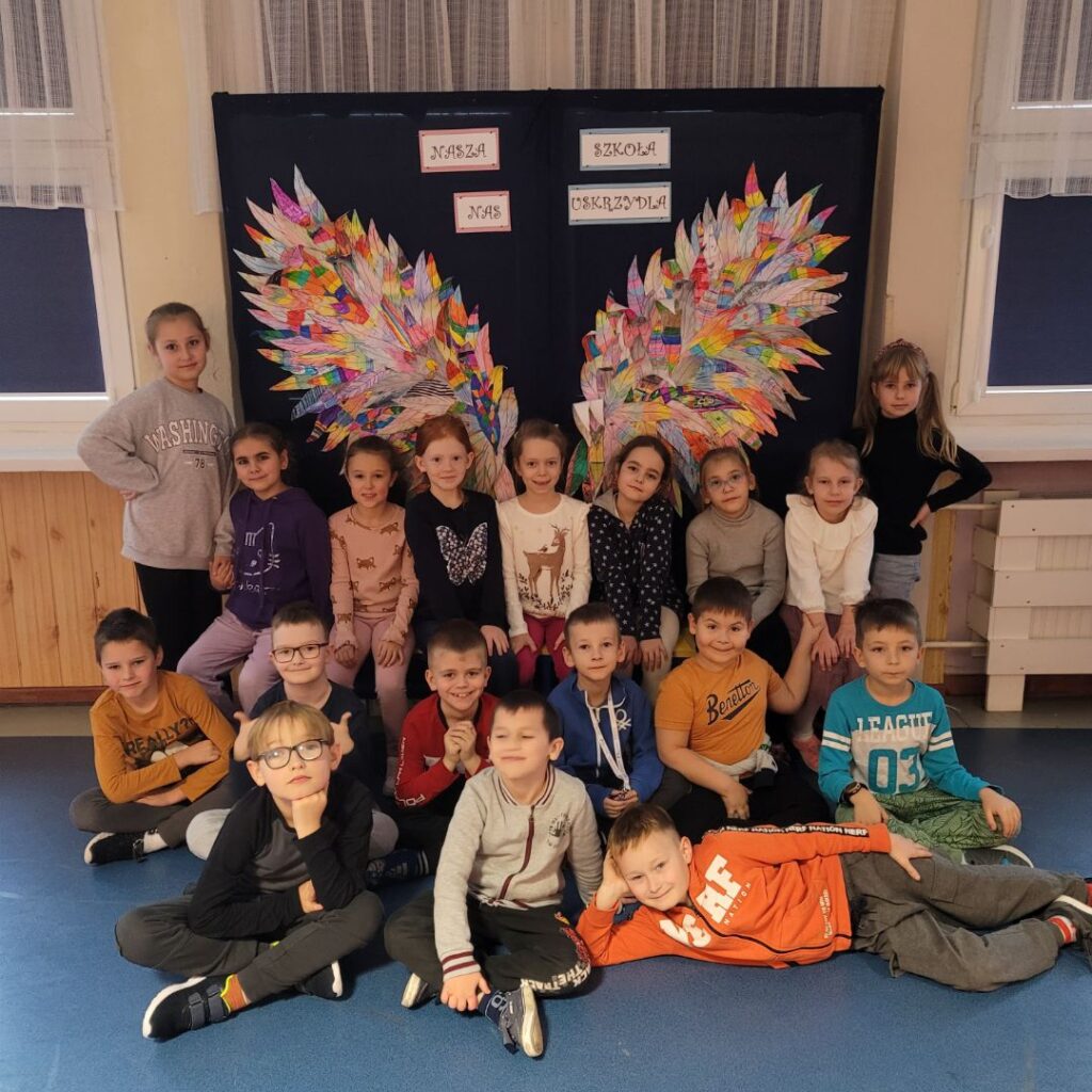 zdjęcie grupowe dzieci na tle ścianki ze skrzydłami