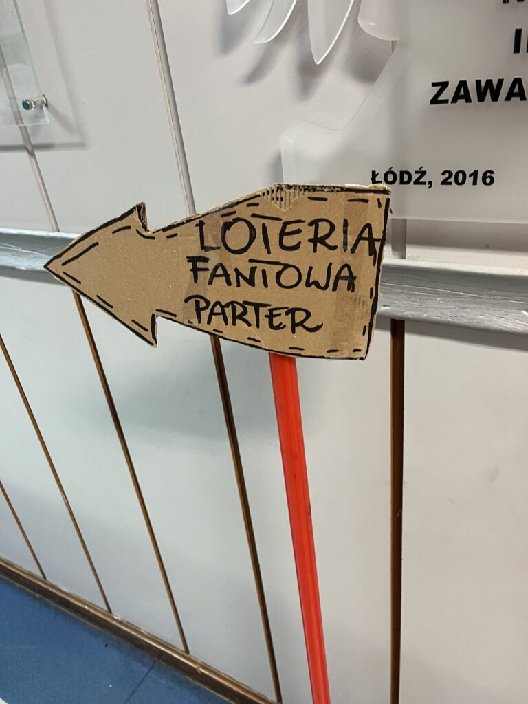 Na zdjęciu widać znak kierujący na loterię fantową 