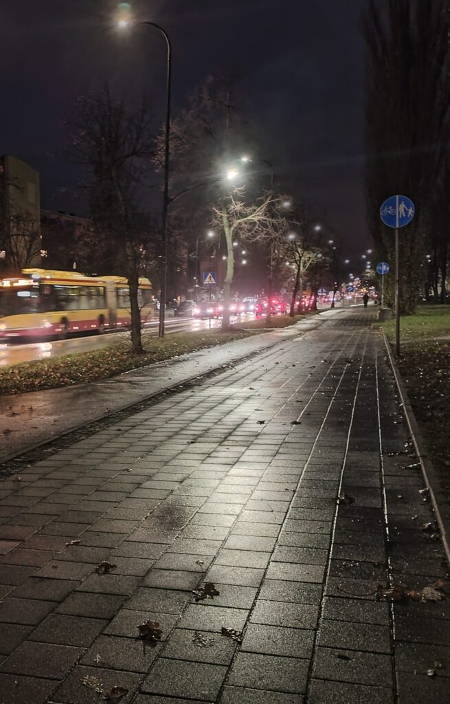 zdjęcie chodnika i aut jadących ulicą