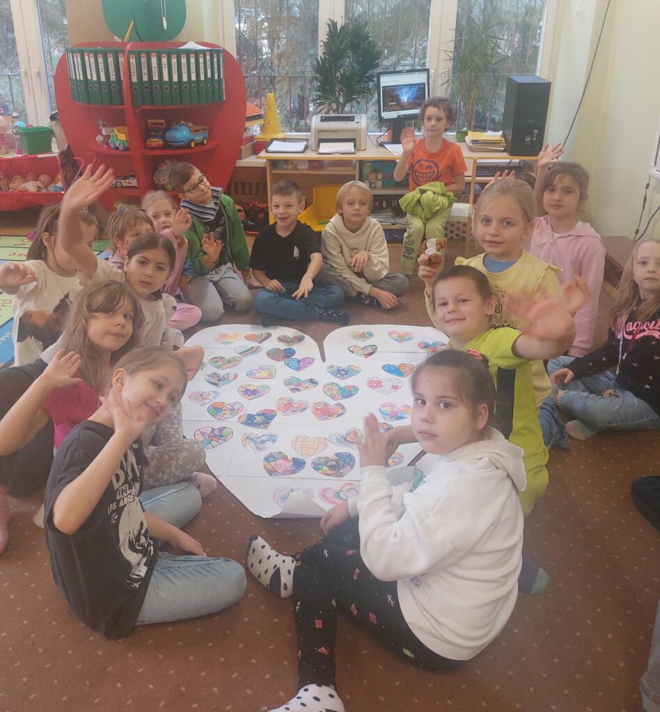 dzieci ustawiły się do zdjęcia wraz z pracą w kształcie serca
