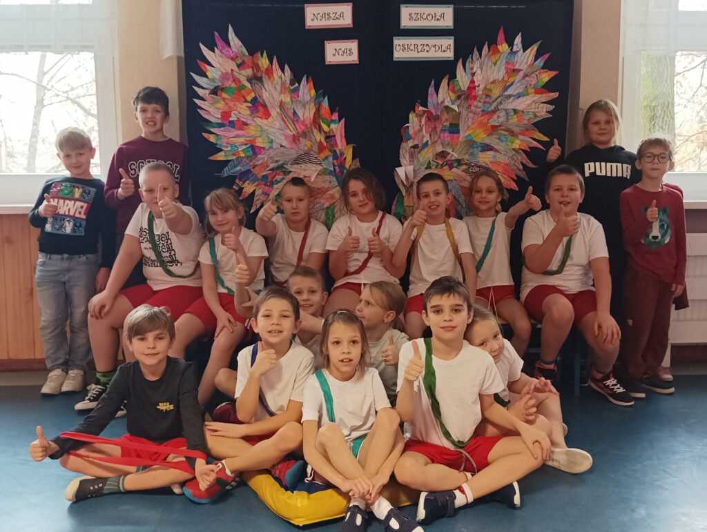 zdjęcie grupowe dzieci na tle ścianki ze skrzydłami