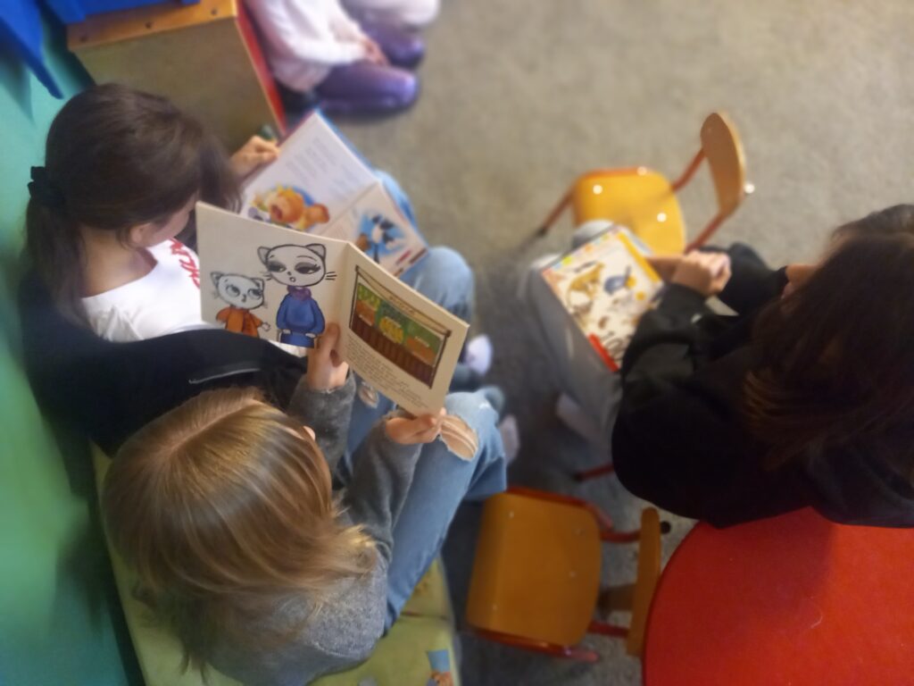 zdjęcie z góry, widać otwartą książkę kici koci