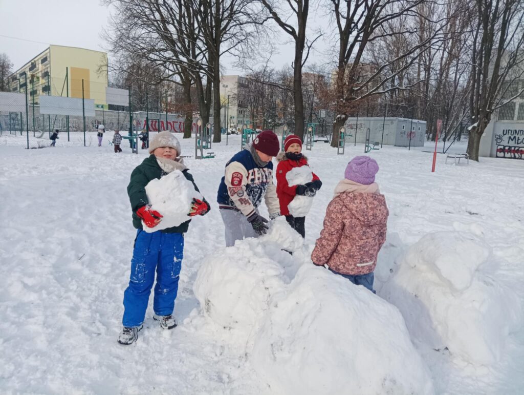 dzieci budują bałwana ze śniegu