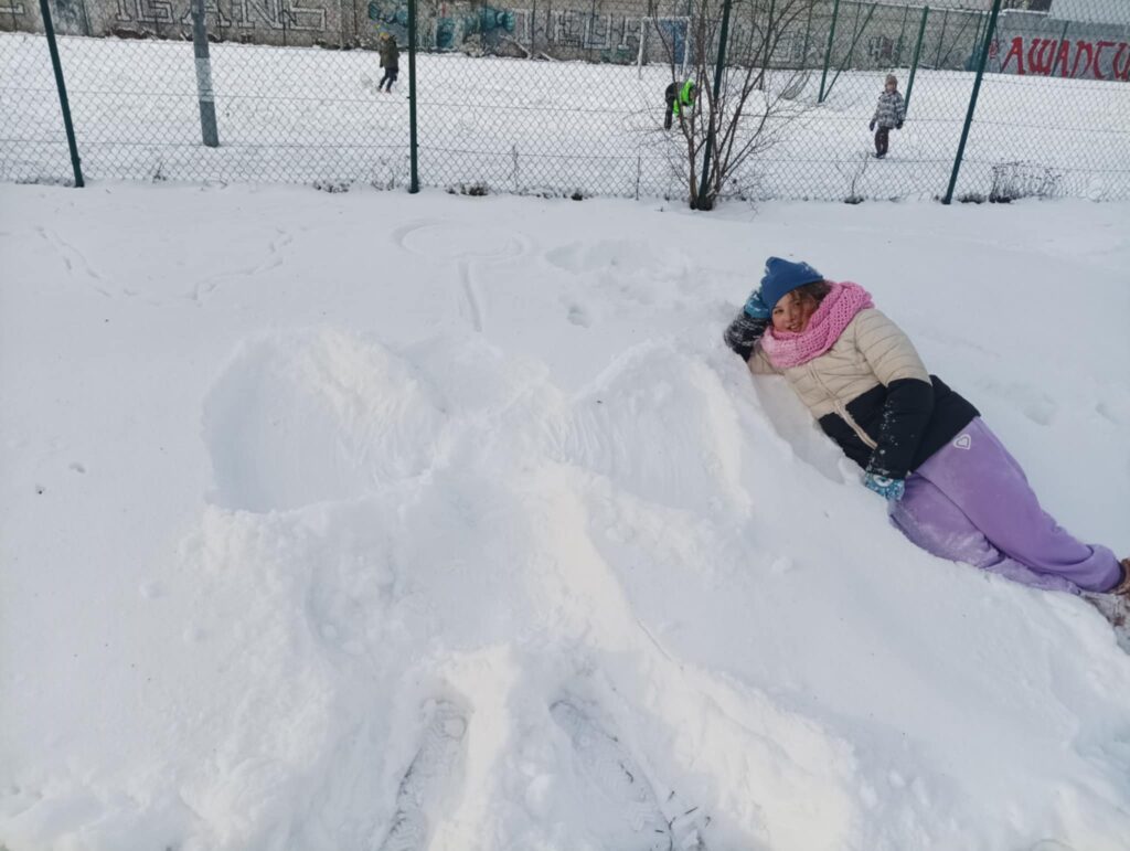 dziecko leży na śniegu