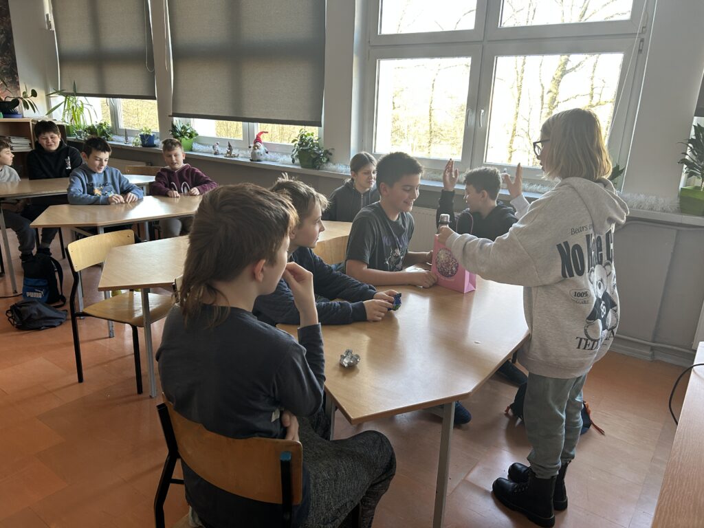 dzieci częstują się cukierkami rozdawanymi przez koleżankę