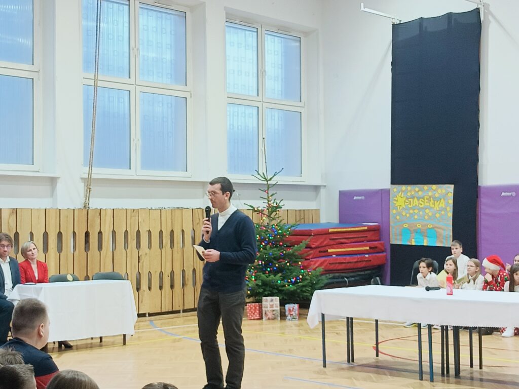 ksiądz przemawia, trzyma opłatek