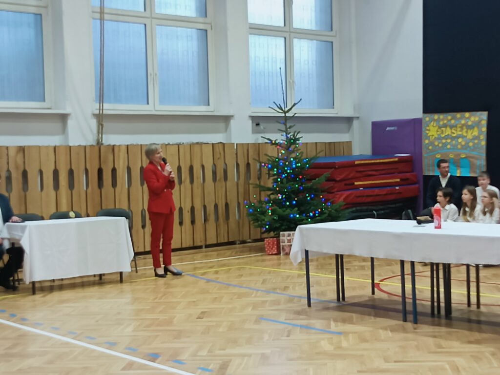 Pani Dyrektor przemawia w tle zielona choinka