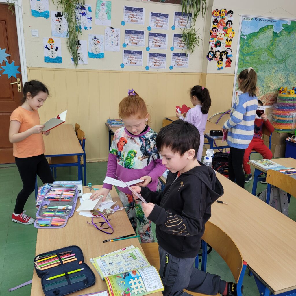 dzieci czytają kolorowe walentynki, kartki, serduszka