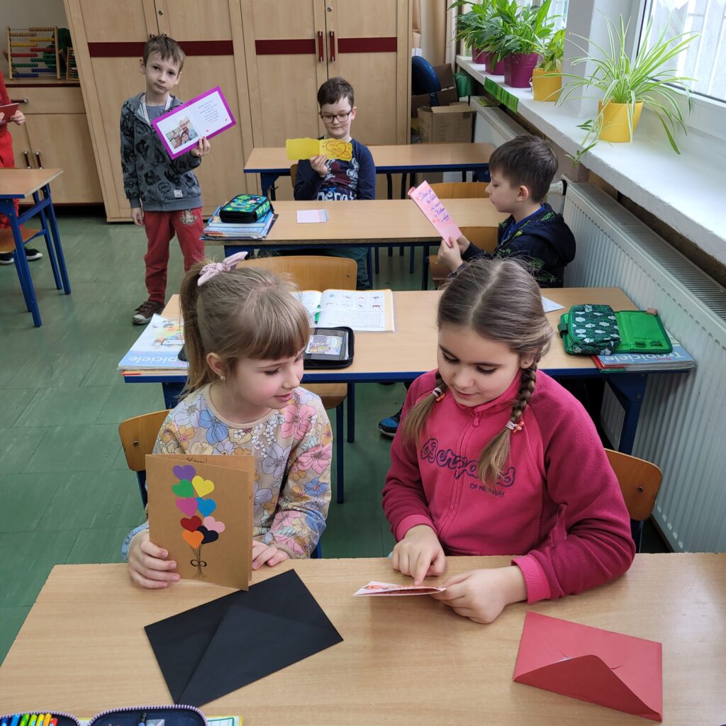 dzieci czytają kolorowe walentynki, kartki, serduszka