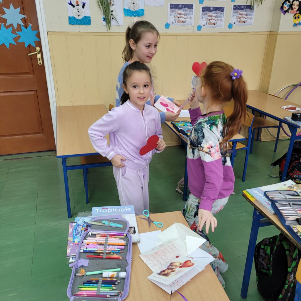 dzieci czytają kolorowe walentynki, kartki, serduszka