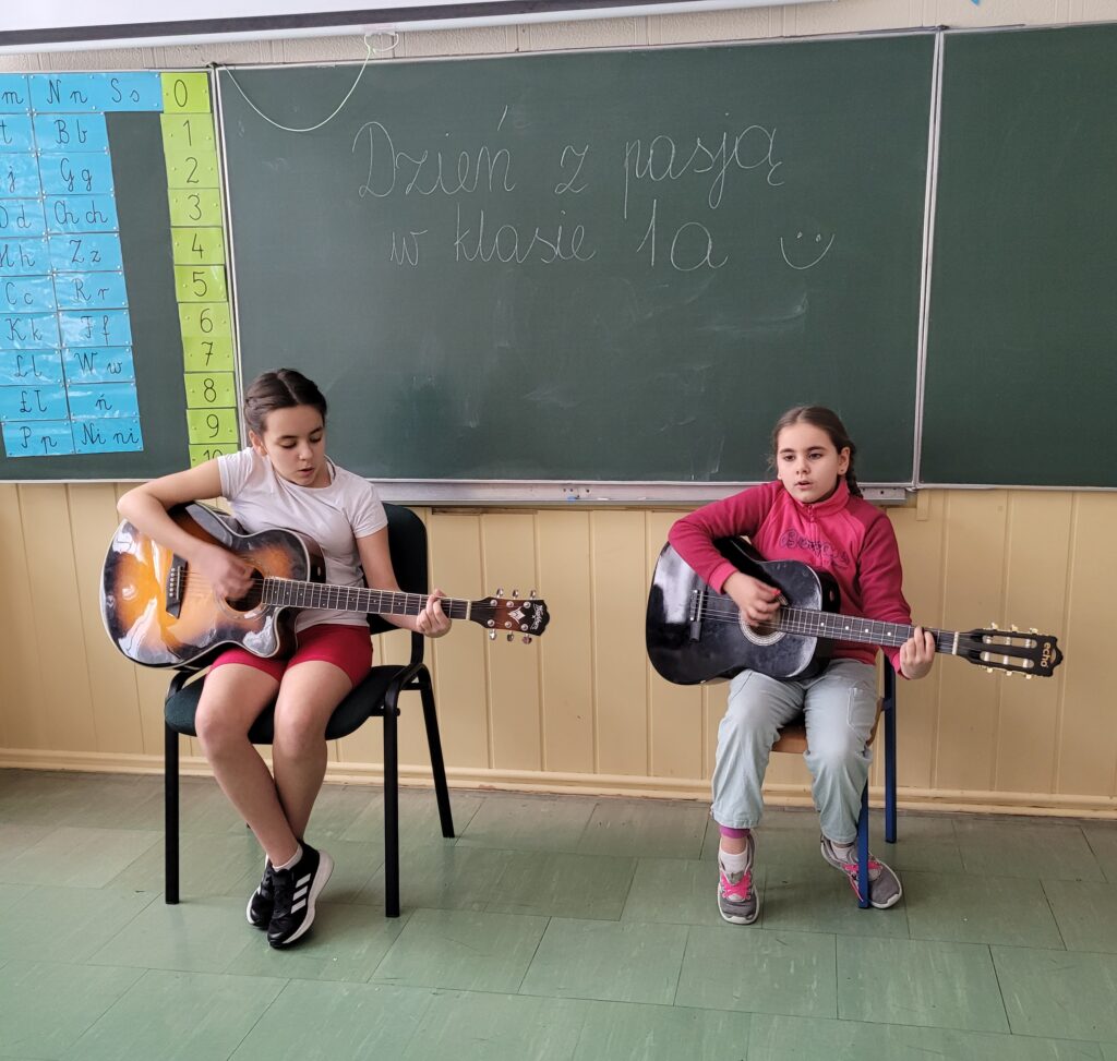 dwie dziewczynki grają na gitarze