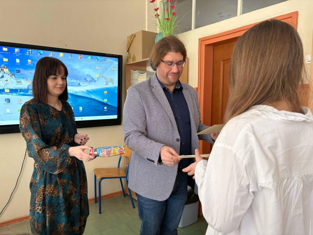 uczennica odbiera nagrodę z dyplomem