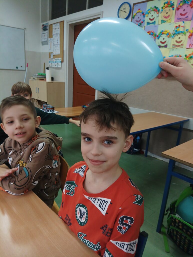 nad chłopcem jest umieszczony balon, jego włosy idą ku górze do niego