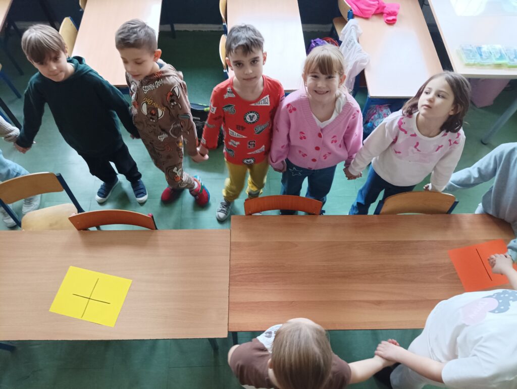 dzieci stoją i trzymają sie za ręce