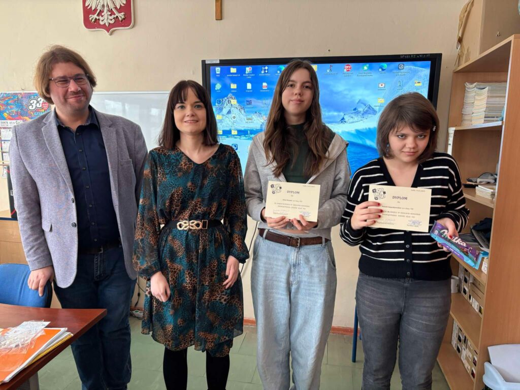 zdjęcie grupowe uczniów z dyplomami, nagrodami i nauczycielem