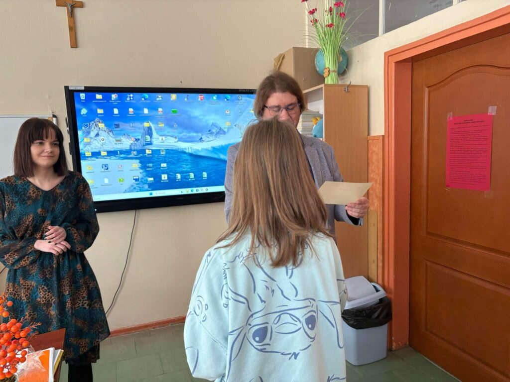 uczennica odbiera nagrodę z dyplomem