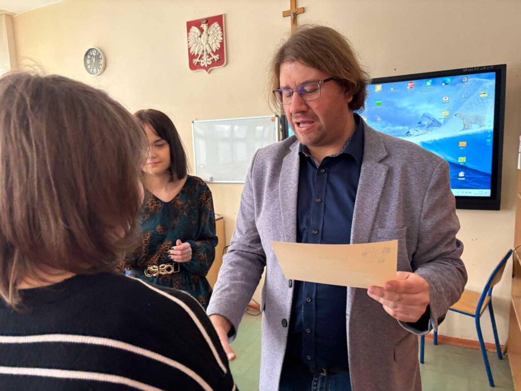 uczennica odbiera nagrodę z dyplomem