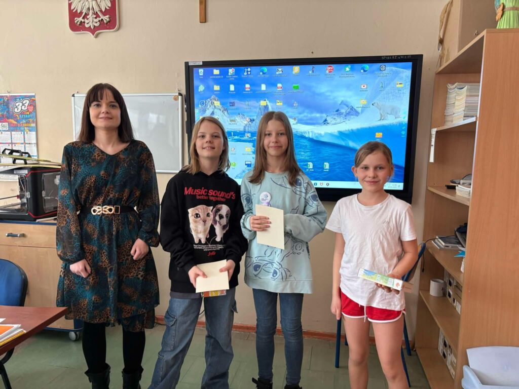 zdjęcie grupowe uczniów z dyplomami, nagrodami i nauczycielem
