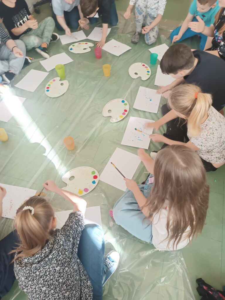 zdjęcie grupy uczniów pracujących razem na podłodze