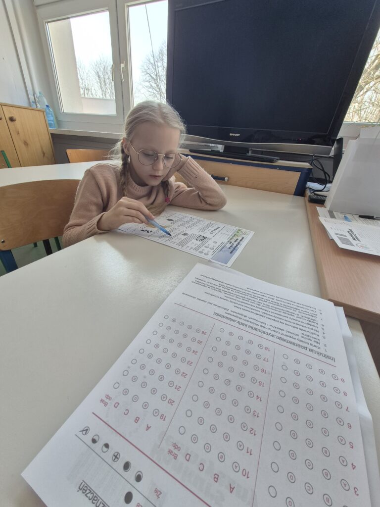 uczennica siedzi i rozwiązuje zadania