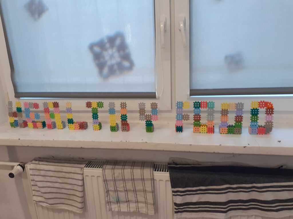 na zdjęciu widzimy na parapecie ułożony przez uczniów napis: „healthy food”.