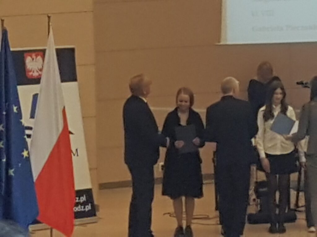 Przedstawiciele władz kuratorium z Łódzkim Kuratorem Oświaty Januszem Brzozowskim na czele wręczają zaświadczenia uzyskania tytułu laureata