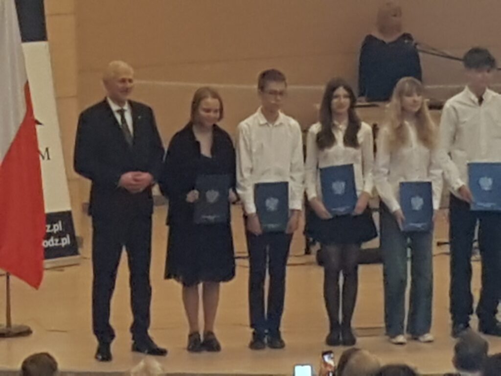Przedstawiciele władz kuratorium z Łódzkim Kuratorem Oświaty Januszem Brzozowskim na czele wręczają zaświadczenia uzyskania tytułu laureata