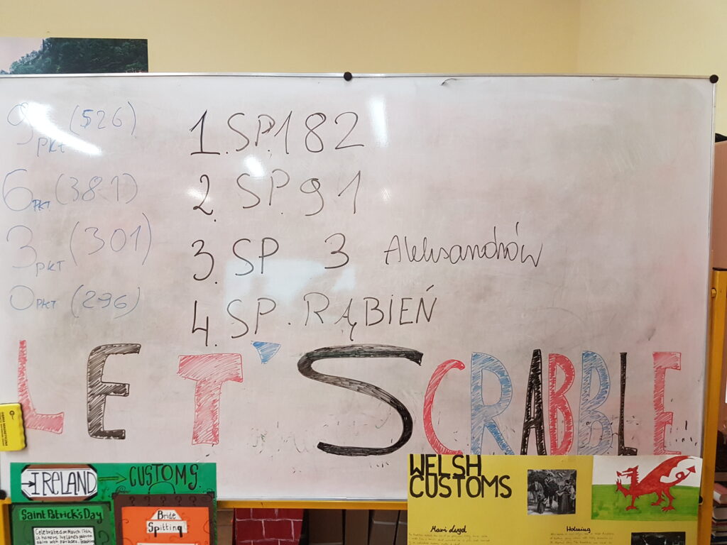 tablica biała z napisami flamastrowymi, scrabble i miejsca w grze