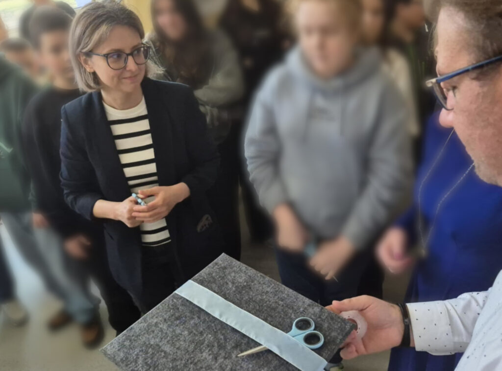 Wicedyrektor wręcza nożyce pani z Rady Rodziców