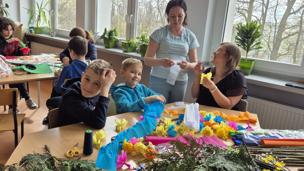 dzieci i dorośli wykonują palmy wielkanocne