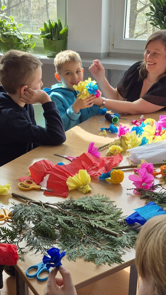 dzieci i dorośli wykonują palmy wielkanocne