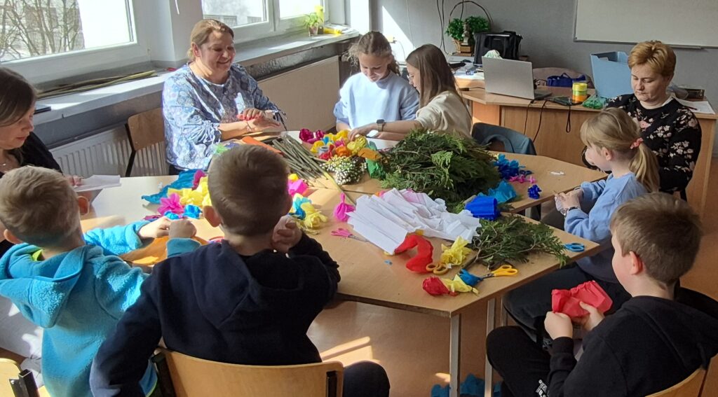 dzieci i dorośli wykonują palmy wielkanocne