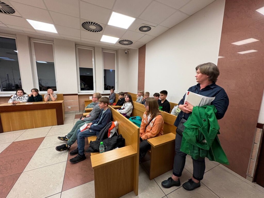 zdjęcie uczniów słuchających pracownika sądu, Pani Dyrektor stoi obok
