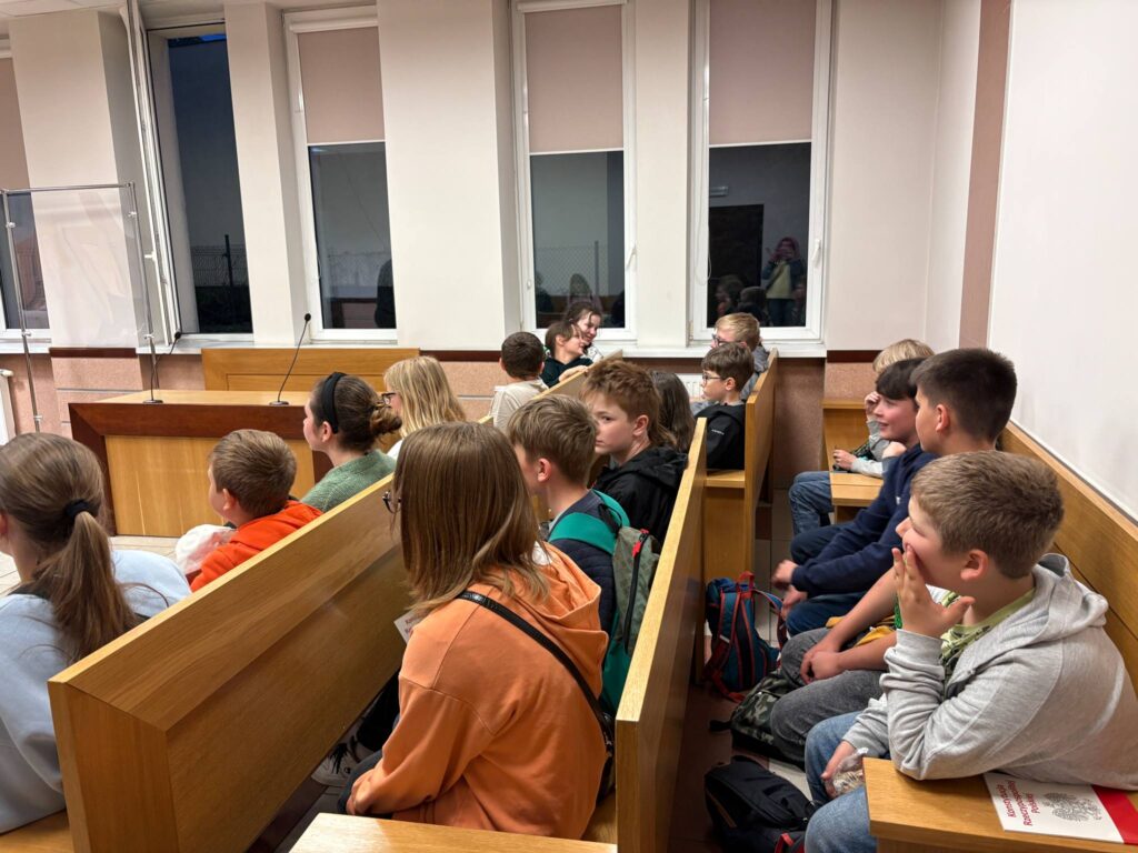 uczniowie siedzą na ławach w sądzie 
