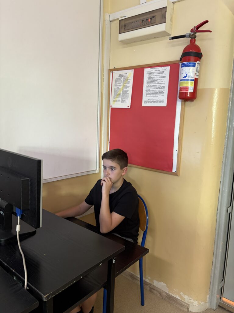 uczeń siedzi przy komputerze i rozwiązuje test