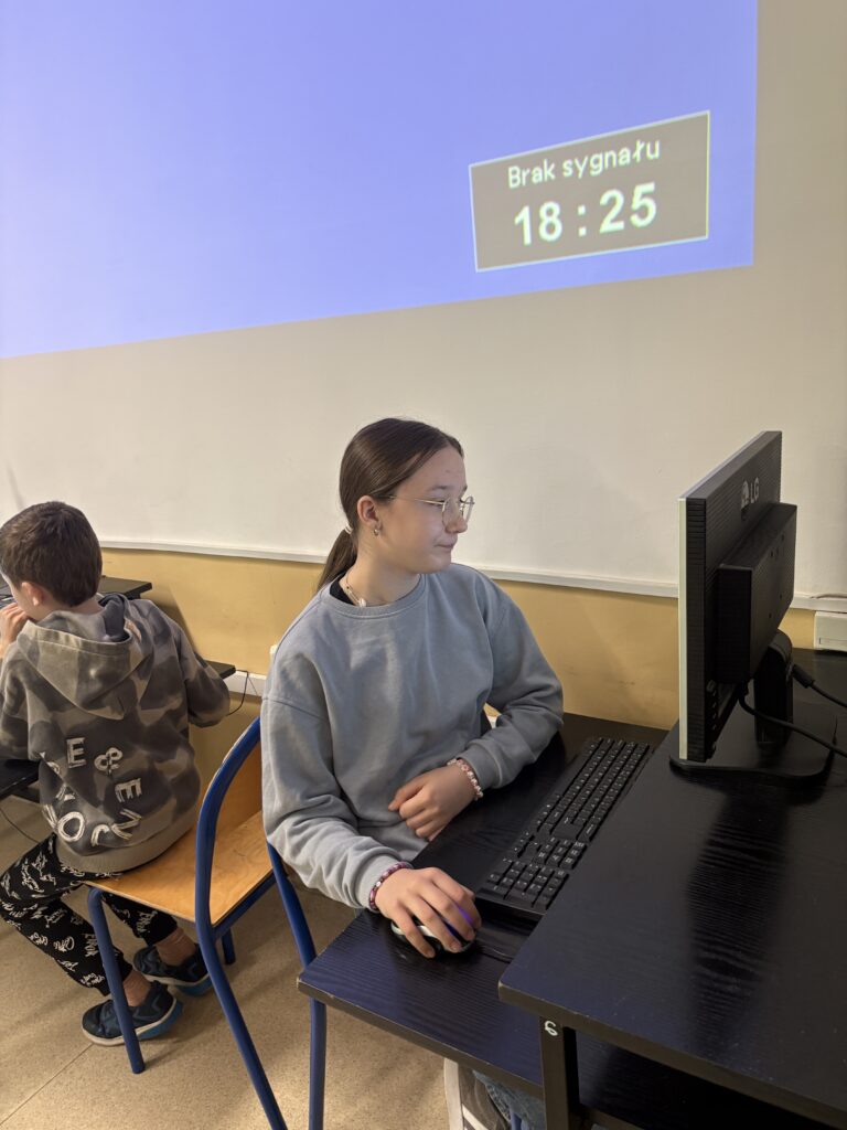 uczeń siedzi przy komputerze i rozwiązuje test