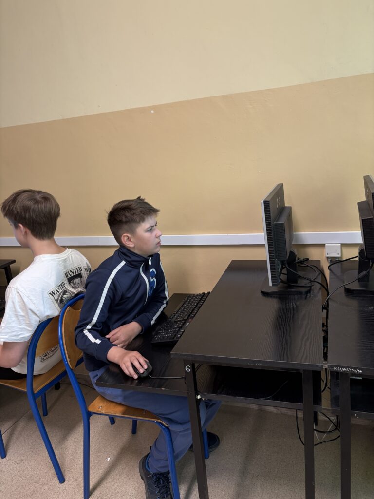 uczeń siedzi przy komputerze i rozwiązuje test