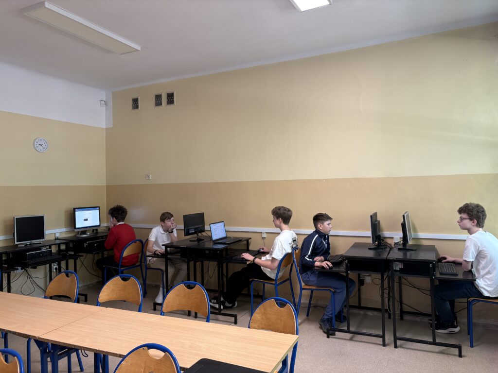 uczniowie siedzą przy komputerze i rozwiązują test