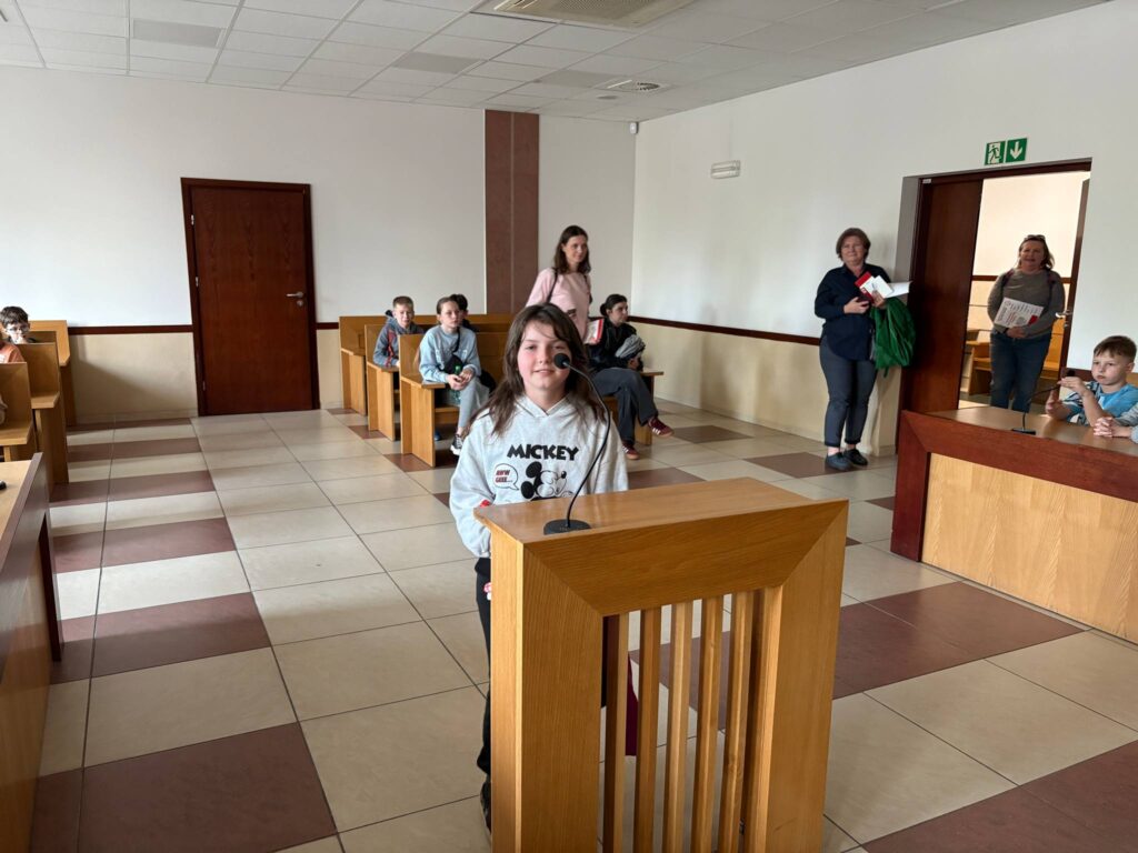 uczennica stoi przed mównicą w sądzie