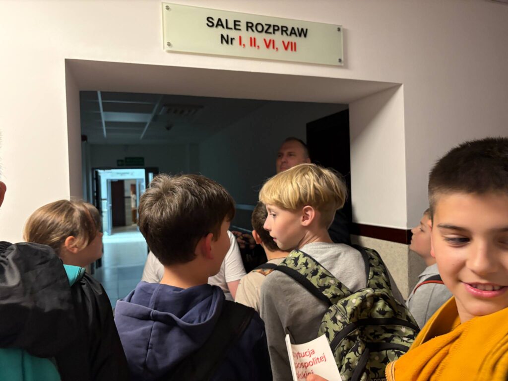 uczniowie stoją na korytarzu w drodze do sal rozpraw