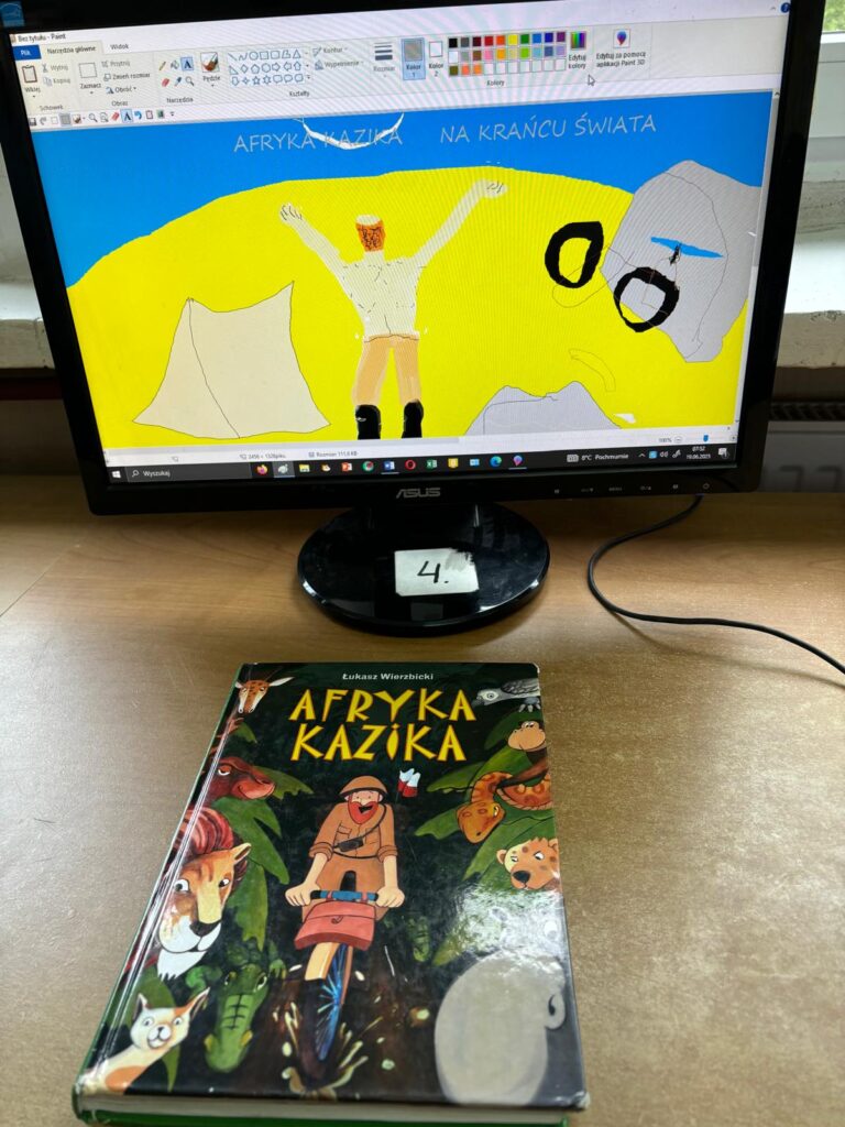 Ekran komputera z pracą ucznia wykonaną w programie paint. Obrazek przedstawia osobę z podniesionymi ramionami na żółtym tle i napis Afryka Kazika na krańcu świata.