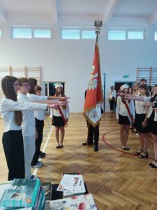 zdjęcie podczas ślubowania uczniów, wyciągnięte ręce do sztandaru