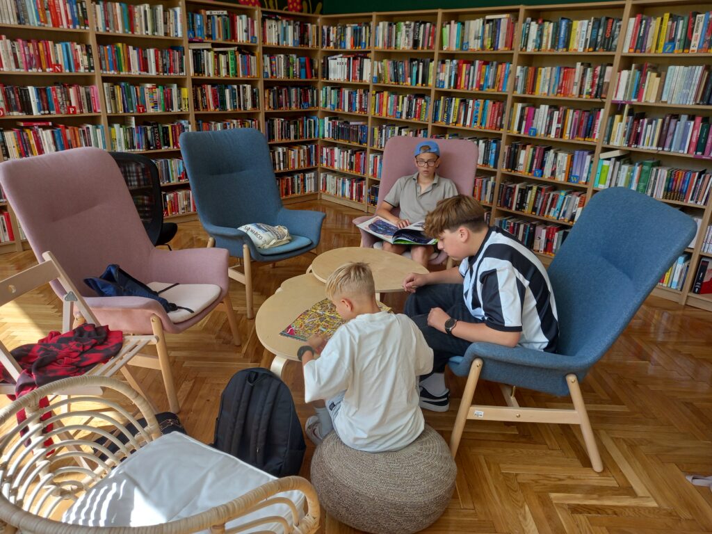 uczniowie siedzą w fotelach w bibliotece